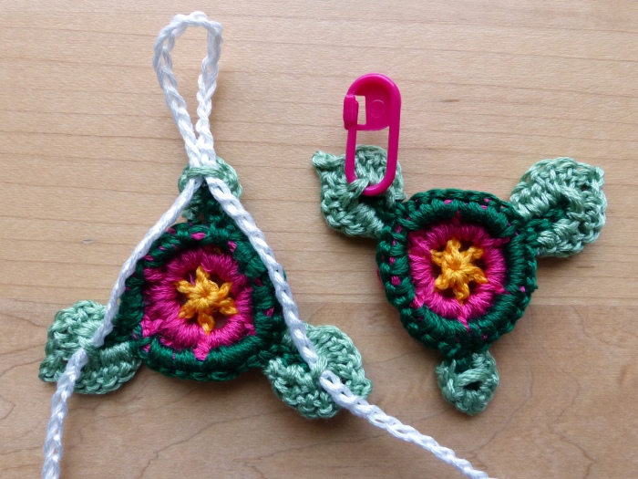 Use the tails to sew loops on the backs of the leaves (as indicated by the stitch marker).  Thread the ties as shown.